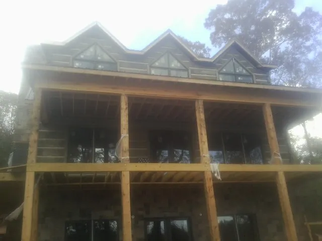 Dormers and porch framing on a large log home under construction — Roof Coating work by our crew in Spokane